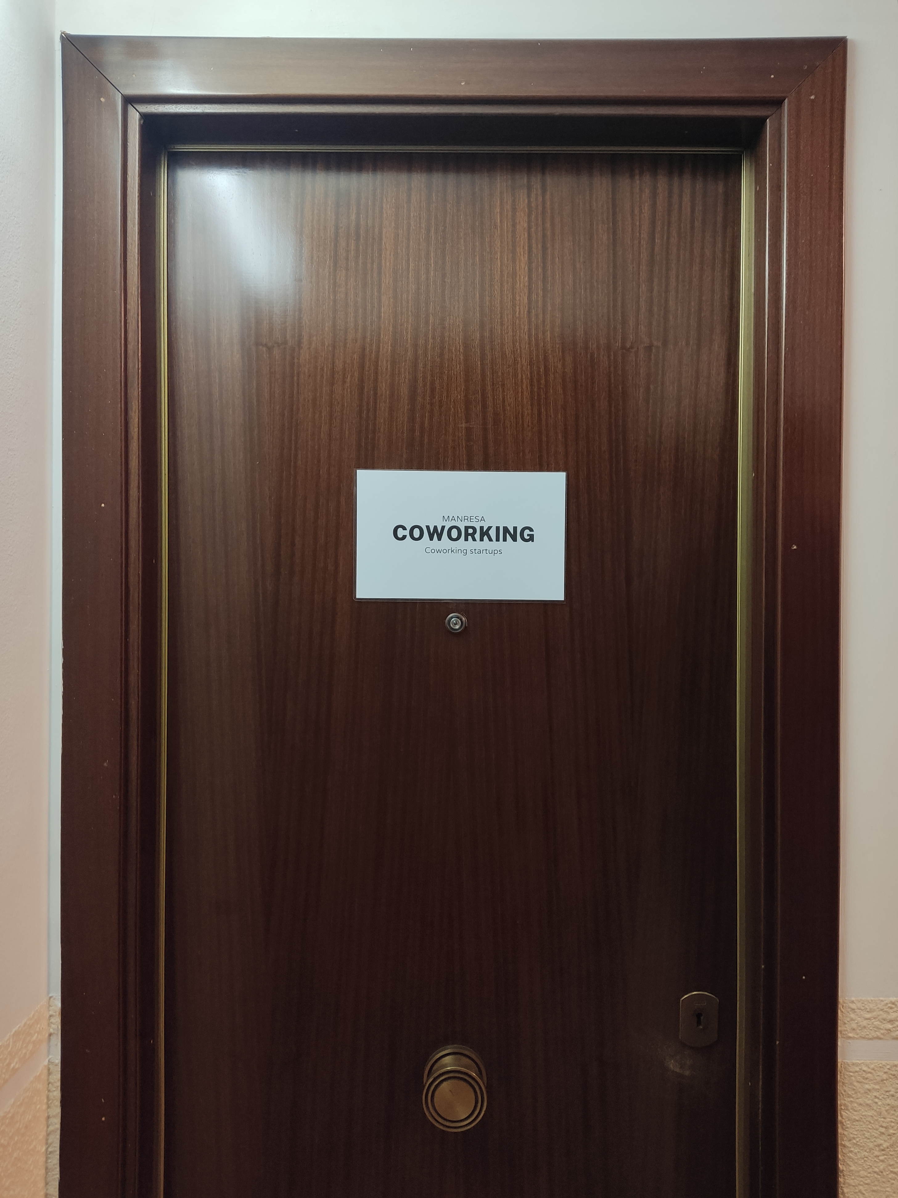 Porta d'entrada del Coworking Manresa amb la placa identificativa al Passeig de la República